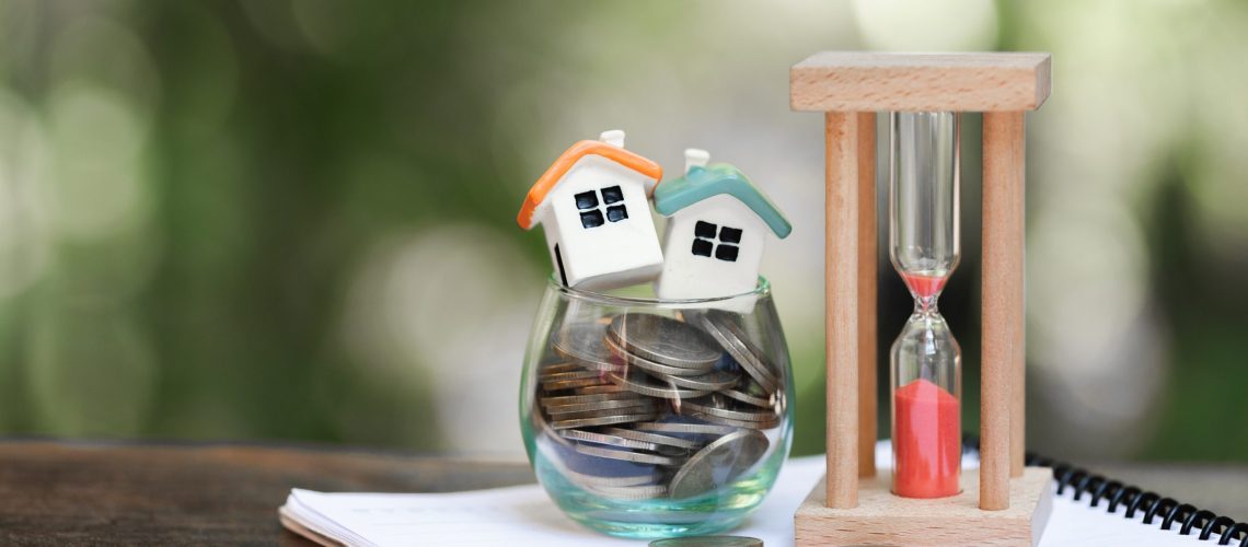 Real estate investment. House and coins on table.